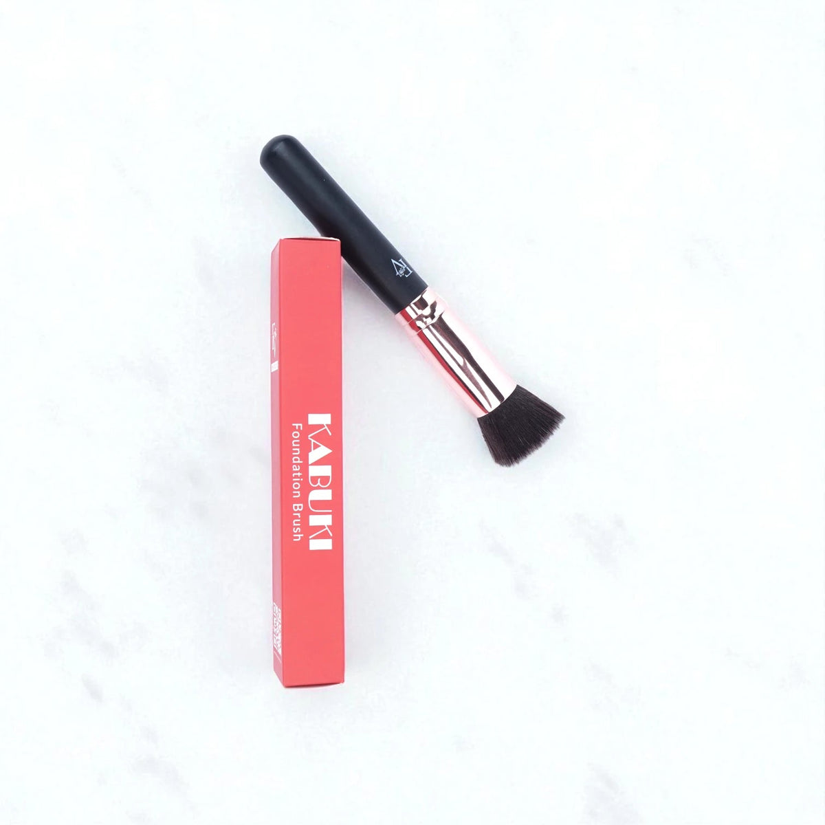 FV Skin Studio Kabuki makeup brush with soft bristles and black handle next to its red product packaging box
